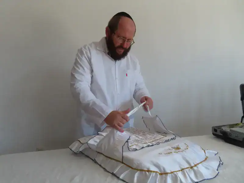 המוהל דב קליין עם כרית לברית מילה