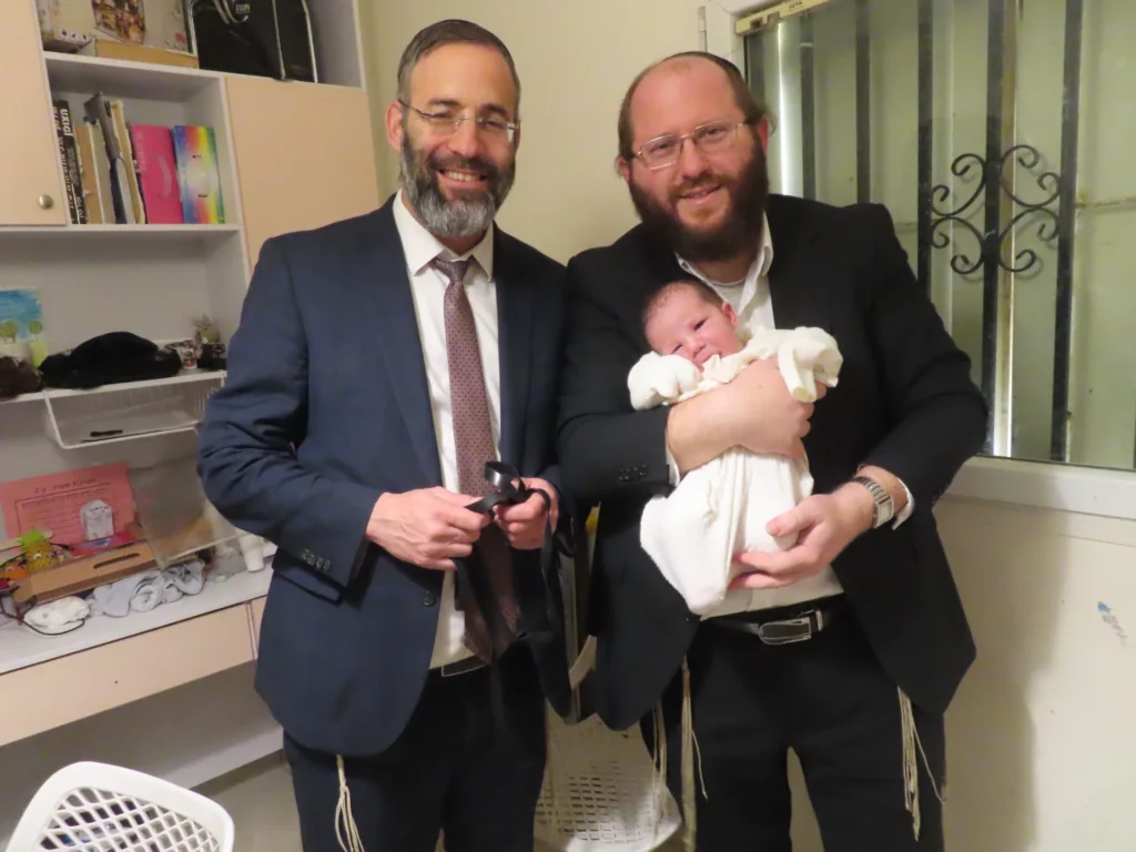 מוהל בודק מכתב שחרור של תינוק עם מדד אפגר נמוך לפני ברית מילה