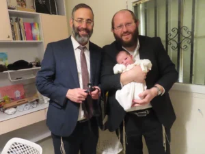 מוהל בודק מכתב שחרור של תינוק עם מדד אפגר נמוך לפני ברית מילה