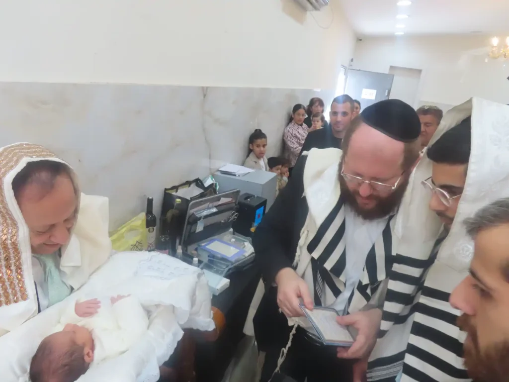 מוהל בודק תינוק לפני ברית מילה בעקבות הצטננות ונזלת