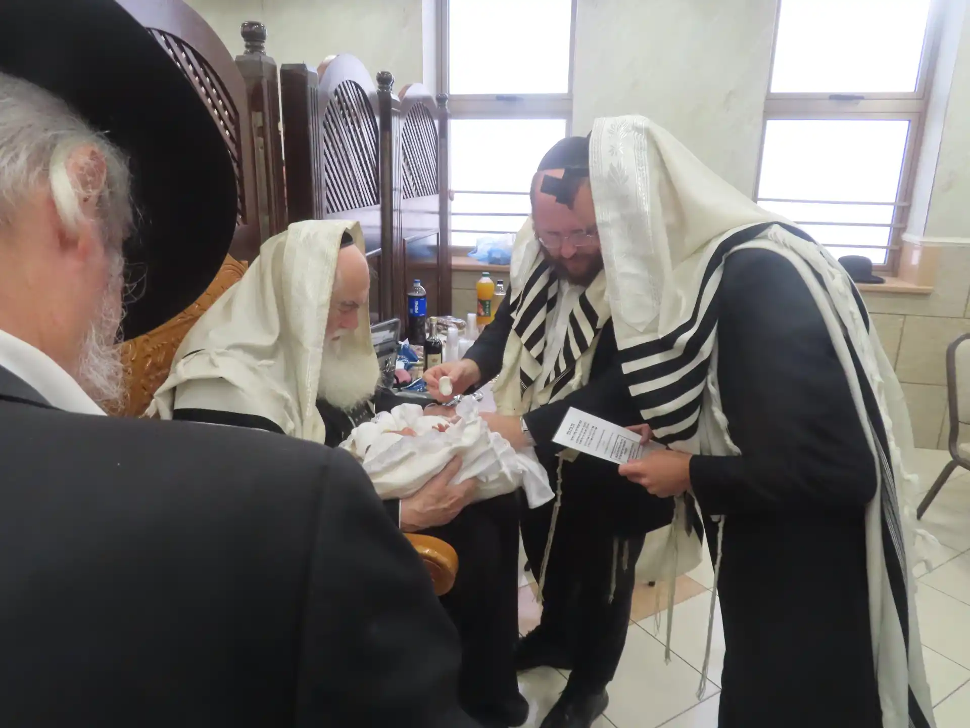 מוהל מומלץ בתל אביב מחזיק את התינוק בטקס הברית